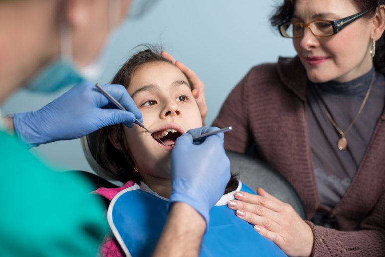 A young girl is being examined by an adult.