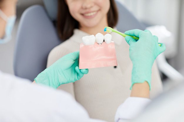 A woman is holding a tooth brush and paste