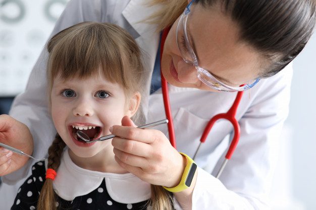 A young girl being examined by a doctor.